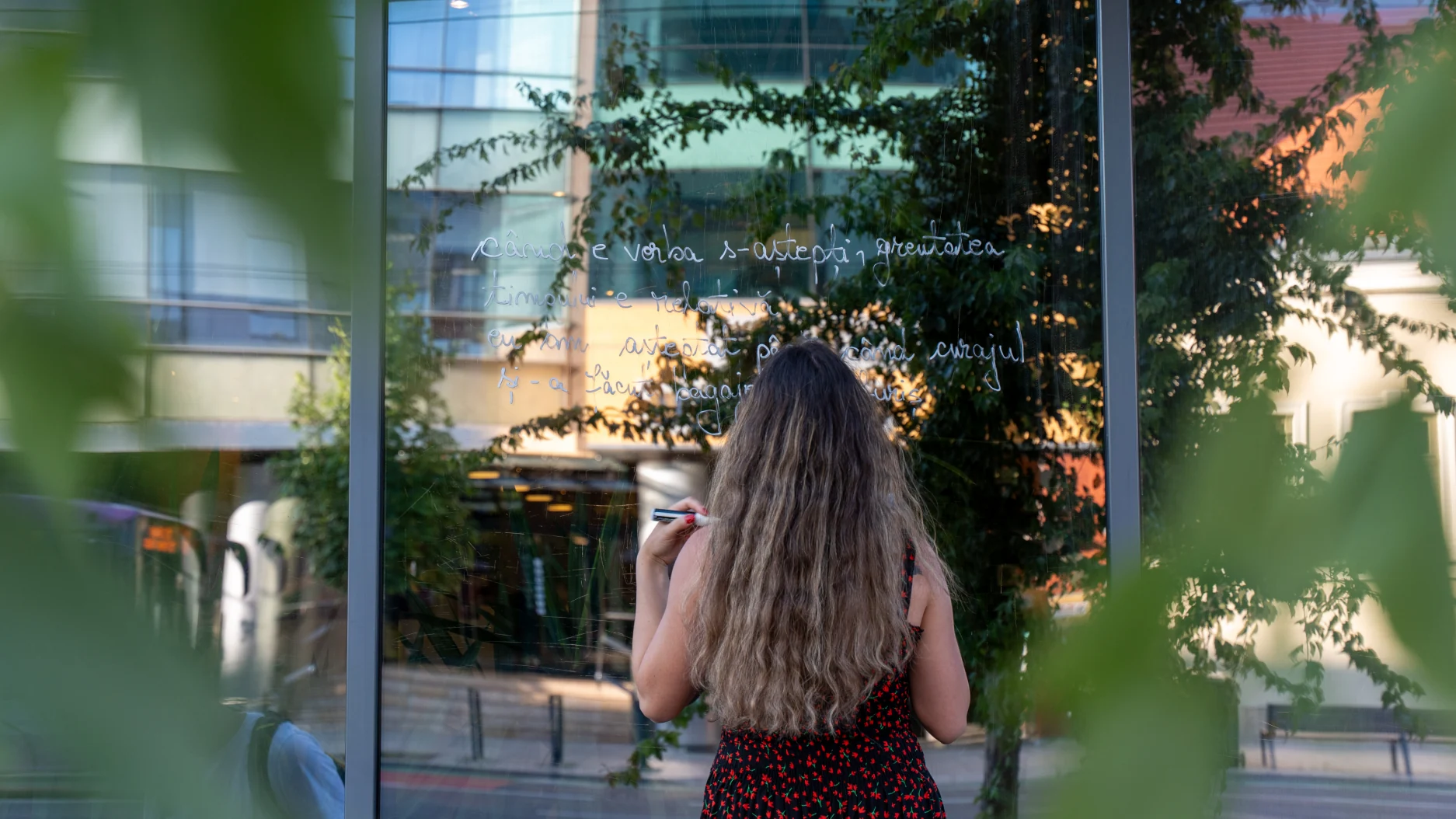 Izabella Lukacs scrie propriile poezii pe geamurile din centrul Clujului în cadrul proiectului Geamul cu poezie