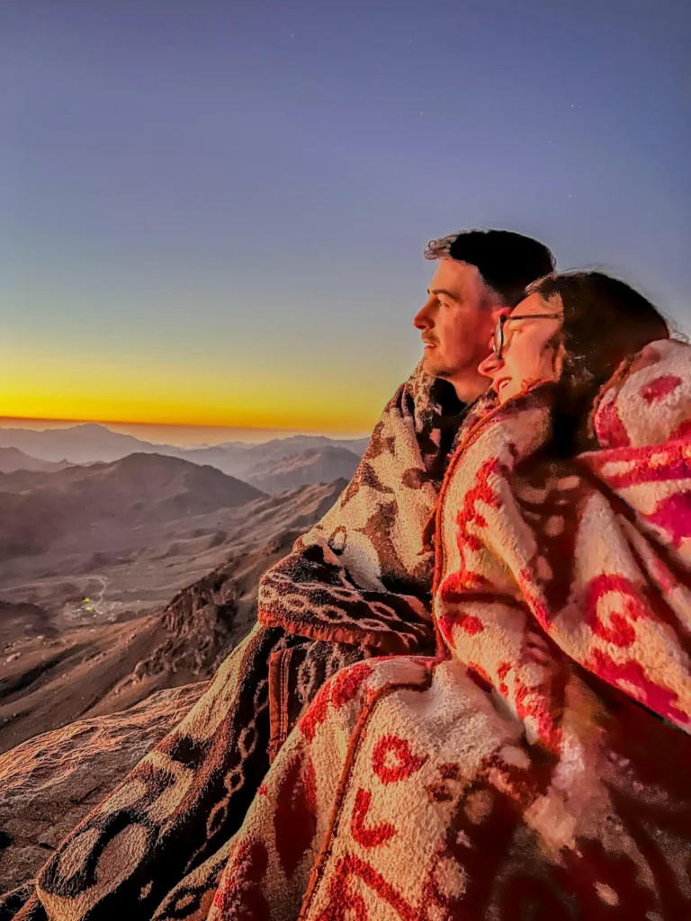 Maria și Emi (Lumea pe fugă) - Fotografie 2025, răsăritul pe vârful Muntelui lui Moise - 2285m, după un traseu de noapte însoțiți de beduini. Pensinsula Sinai, Egipt-izabellalukacs.ro